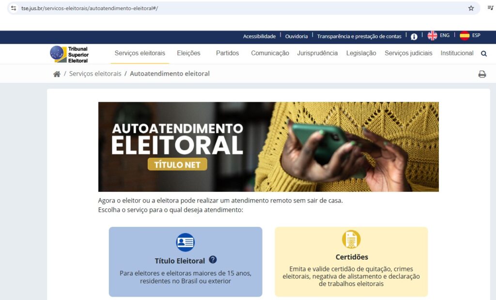 O topo da tela exibe o cabeçalho do site do Tribunal Superior Eleitoral (TSE). Logo abaixo, uma grande imagem central apresenta o título "AUTOATENDIMENTO ELEITORAL TÍTULO NET" em letras brancas sobre um fundo escuro. A imagem também mostra as mãos de uma pessoa de pele parda ou negra segurando um smartphone, vestindo uma blusa de lã amarela. O texto abaixo informa que o eleitor ou a eleitora pode pedir atendimento remoto sem sair de casa. A tela oferece duas grandes caixas de opção em destaque: Título Eleitoral: Para eleitores e eleitoras maiores de 15 anos, residentes no Brasil ou exterior. Certidões: Emite e valida certidão de quitação, crimes eleitorais, negativa de alistamento e declaração de trabalhos eleitorais.